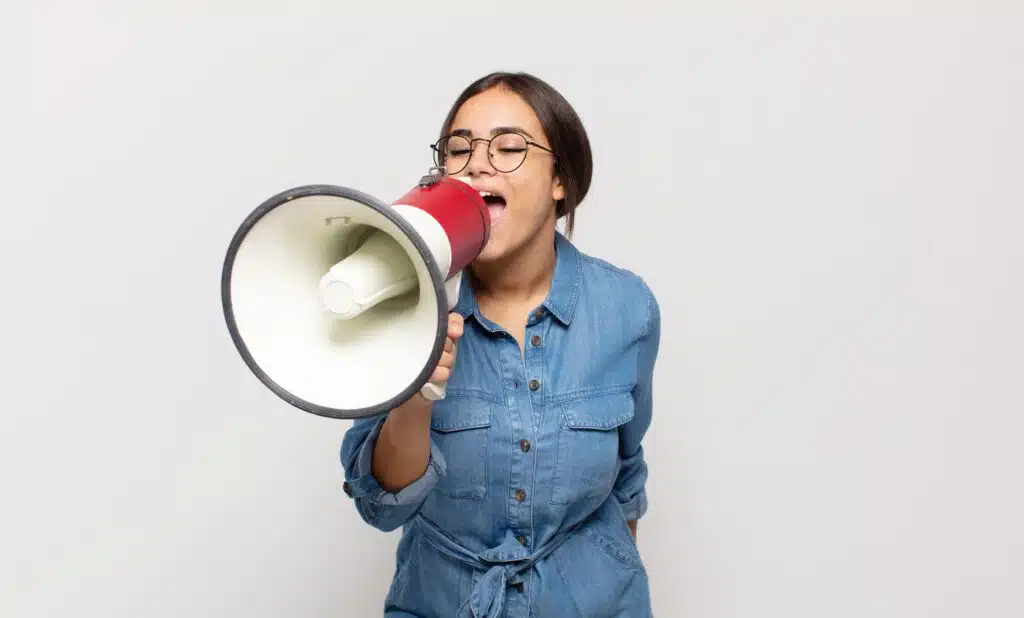 young hispanic woman feeling happy excited positive giving big shout out with hands mouth calling out 4 - DT Network