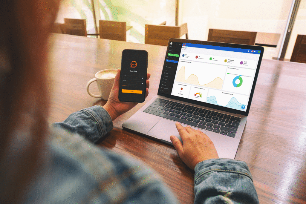 pessoa em uma mesa com notebook e celular acessando o chat corp simbolizando o whatsapp para empresa como funciona.