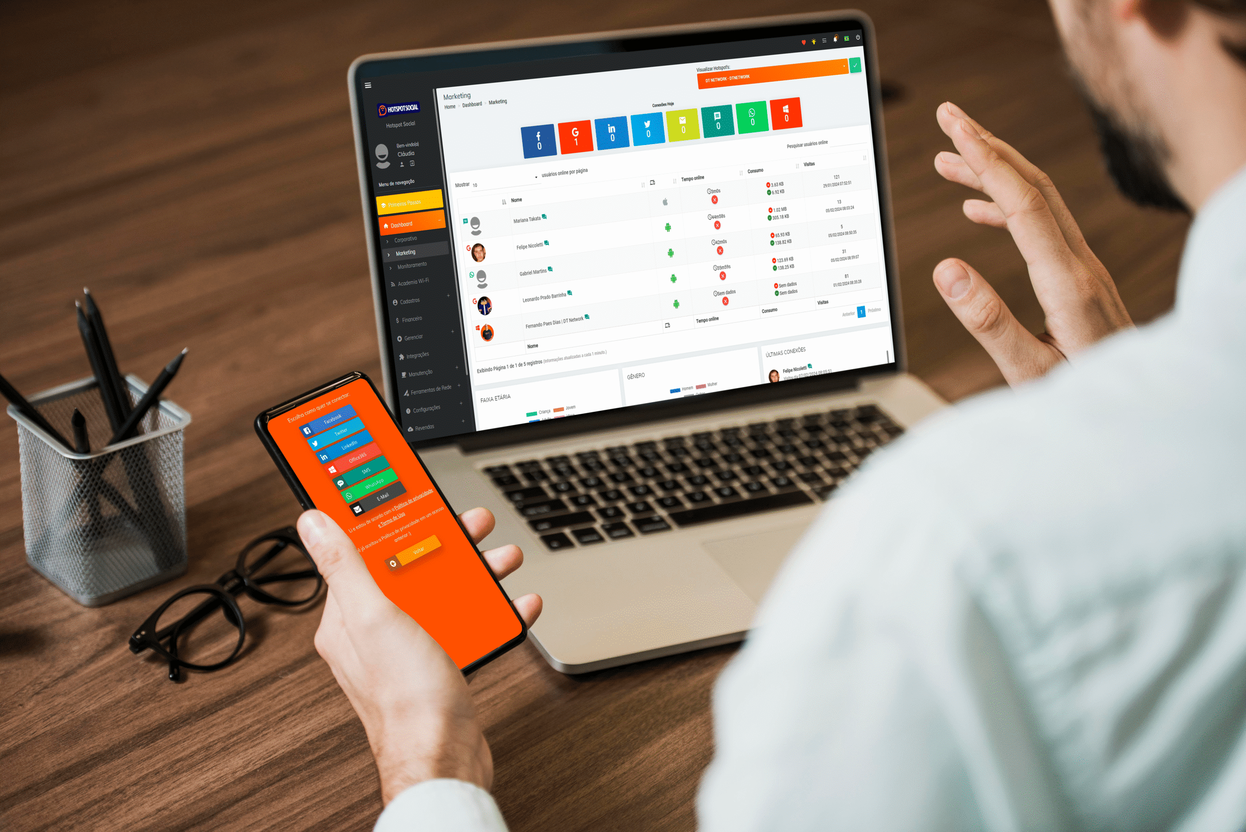 pessoa em seu escritório com notebook e celular na mão com imagens de dados de pessoas conectadas no hotspot social simbolizando hotspot o que é