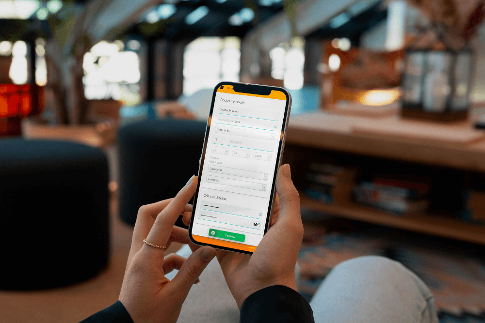 pessoa no lobby do hotel sentado acessando o wi-fi pelo celular simbolizando o hotspot social e como wifi para hotel aumenta reservas diretas